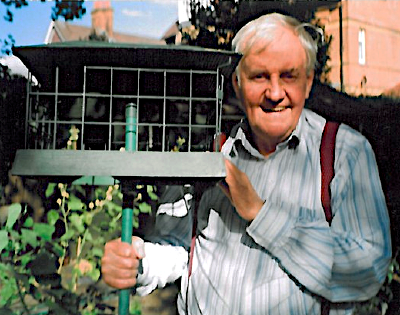 Actor Richard Briers holding a bird cage